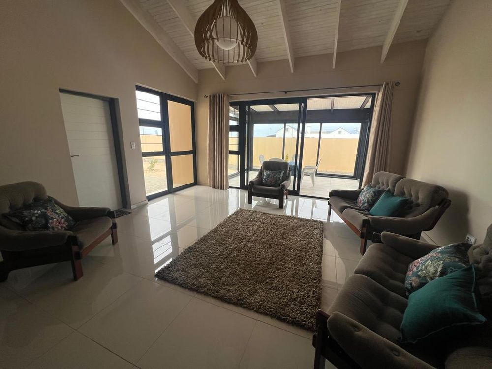 Entrance with small living area. To the left, one of the garage entrances and to the right, an enclosed patio