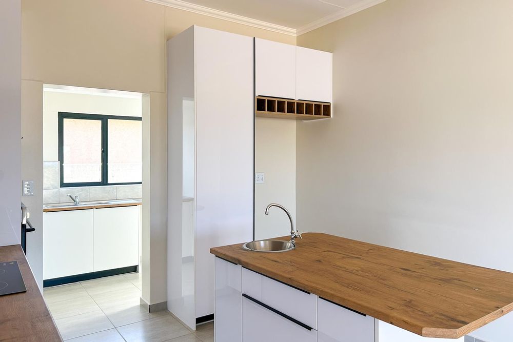 Large kitchen with white gloss cupboards and kitchen island.