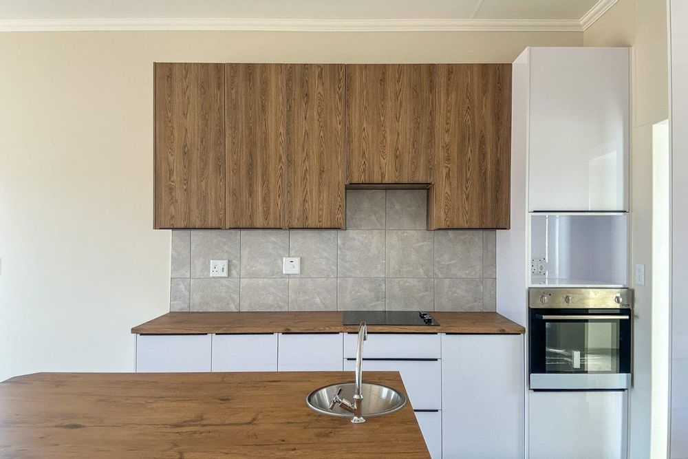 Large kitchen with white gloss cupboards and kitchen island.