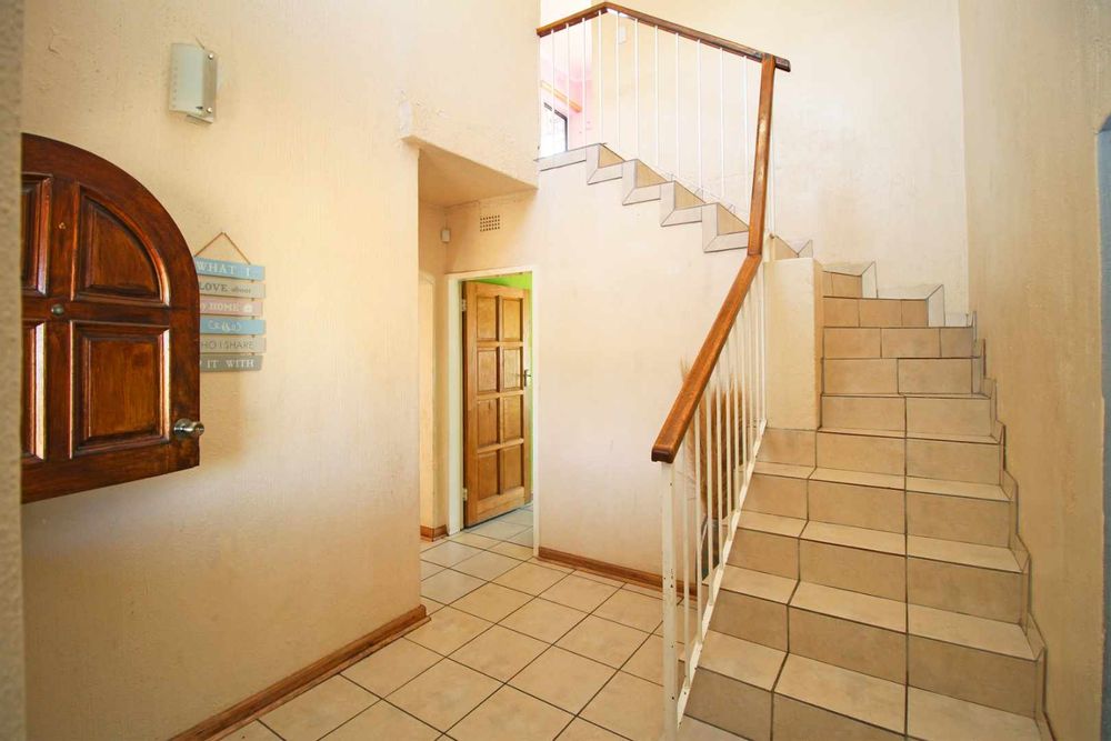 Front Door Entrance and Foyer as you enter the home.  From this landing space you can access the Formal Lounge, the Staircase leading to the upstairs Main Ensuite Bedroom, the Hallway to the Kitchen and Dining Room as well as the Guest Toilet
