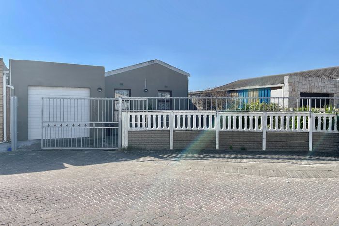 Affordable Strandfontein house for sale: fitted kitchen, garage, carport, and paved yard.