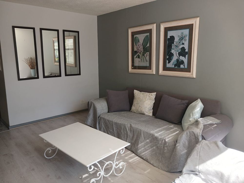 Couch in lounge and mirrors on the wall.