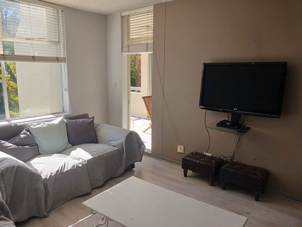 Lounge with TV and door tho balcony.