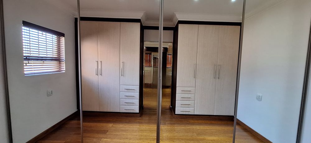 Walk-in closet with full sliding mirror closets.