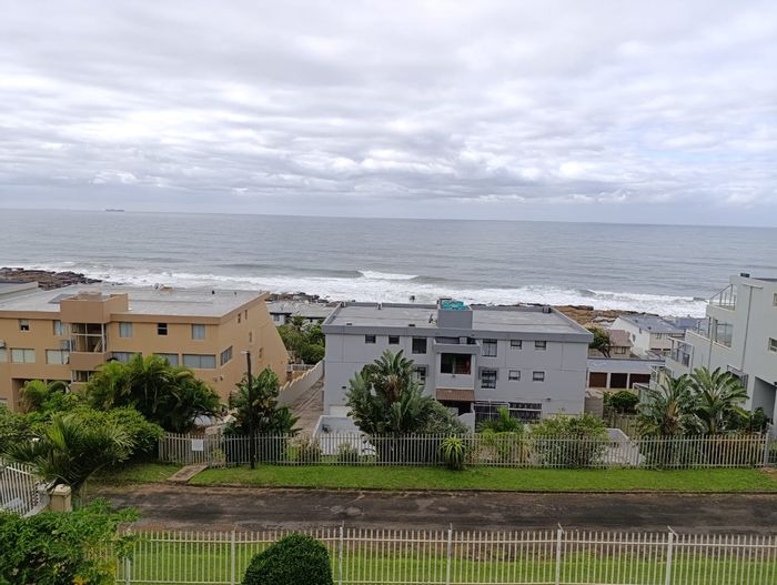 Uvongo Townhouse For Sale: Ocean views, secure parking, close to beach amenities.