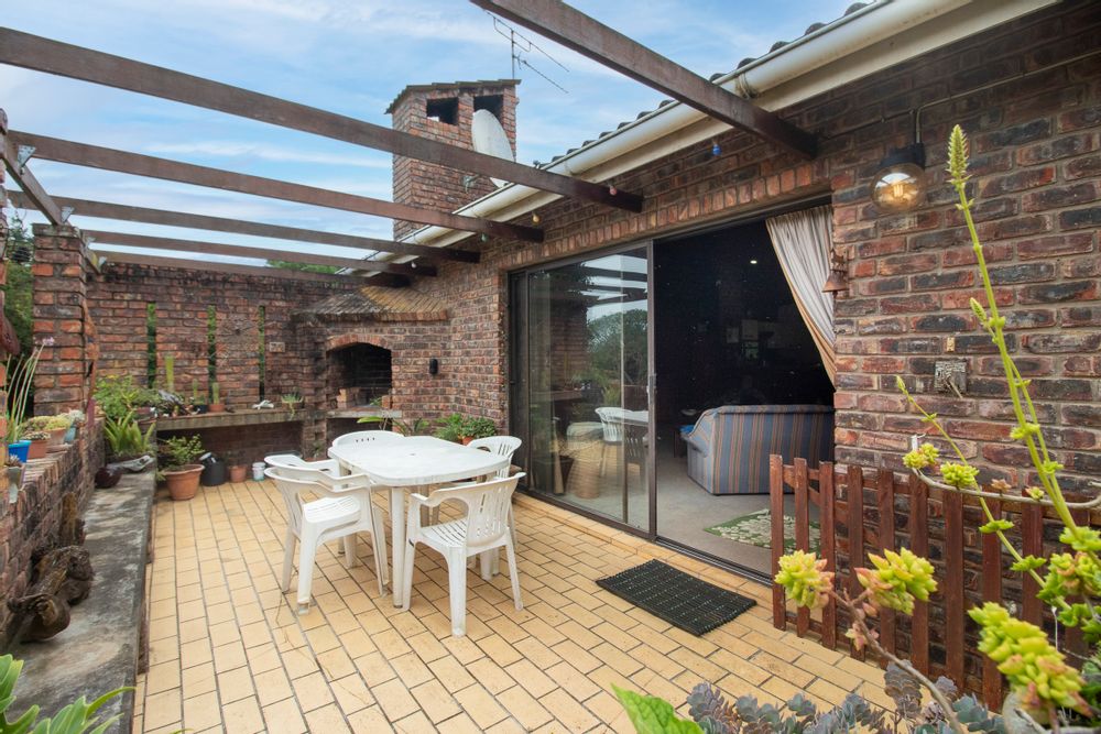 An entertainment area, complete with a braai with internal light leads off of the living area.
