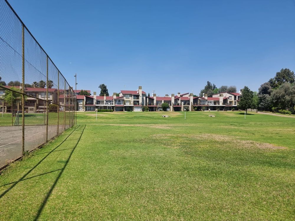Tennis court with complex in back
