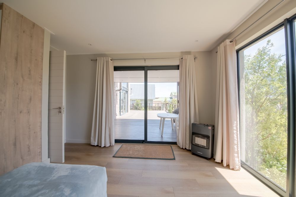 Main bedroom view on lush garden and covered deck area