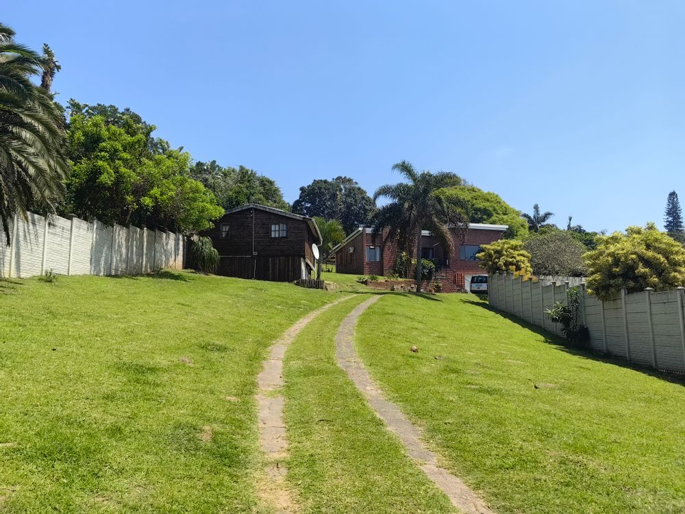 Large grounds with garden cottage in background