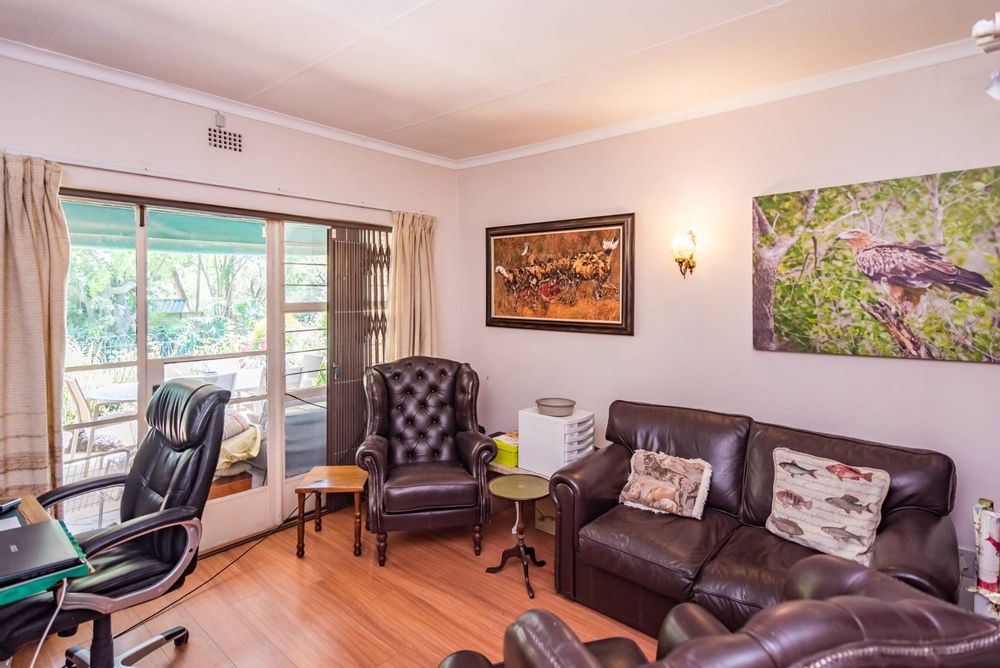 Large study with wooden floors and views of the garden and pool