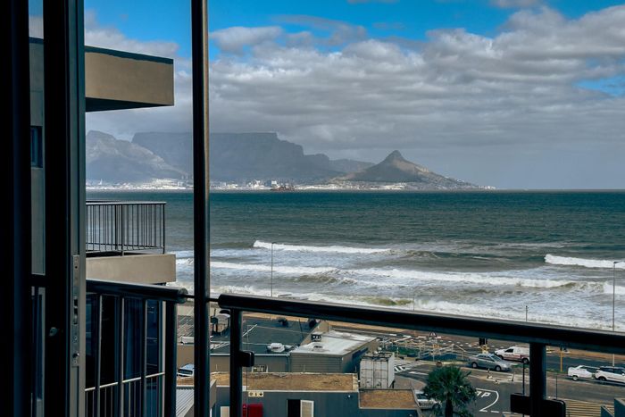 Ocean-facing apartment in Bloubergstrand for sale, includes furniture and transfer duty.