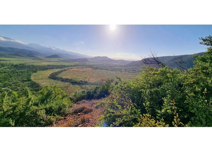 De Rust Farm For Sale: 27.8Ha with cultivated land, water rights, and mountain views.