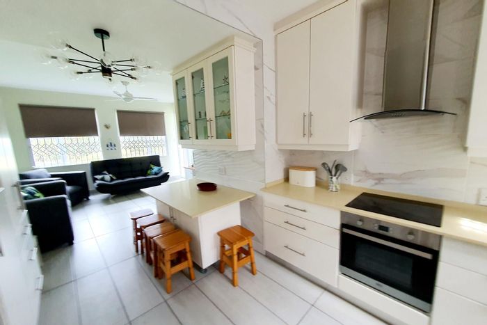 Affordable Uvongo apartment for sale, steps from the beach, with security and amenities.