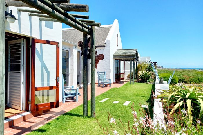 Beachfront house in Jacobsbaai for sale: 4 bedrooms, office, patio, garage.