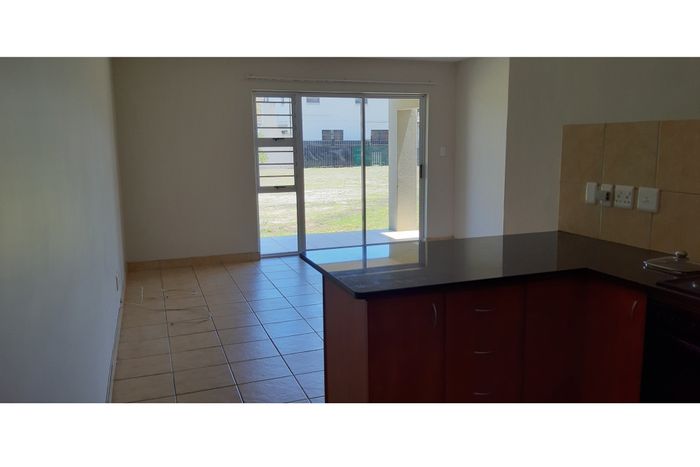 Ground floor apartment in Milnerton Ridge with balcony, parking, and 24-hour security.