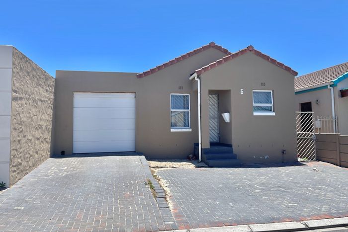 Neat 2-bedroom house in Strandfontein with garage, fitted kitchen, and backyard. For Sale.