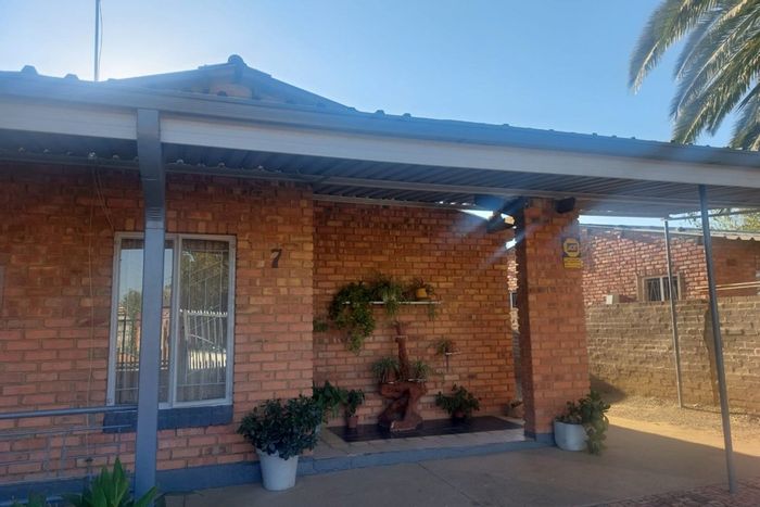 Roodepan House For Sale: Lounge, kitchen, carport, garden, and one-bedroom flat.