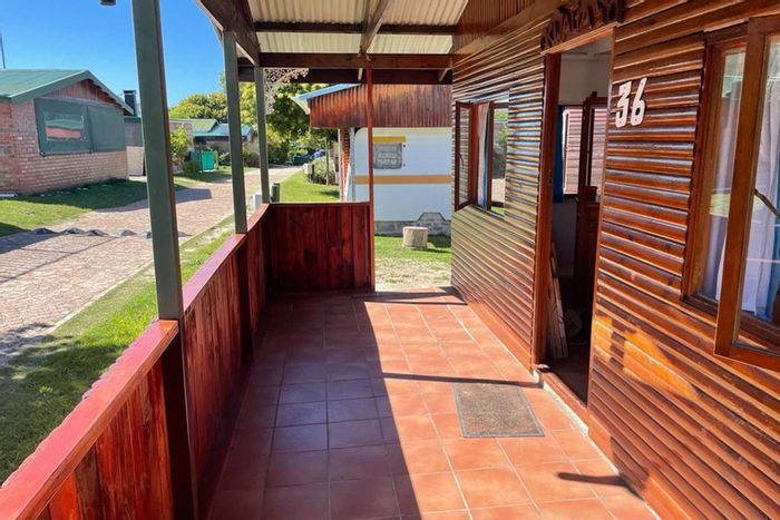House To Rent in Onrus: 1-bedroom cabin with pool, garden, and parking.