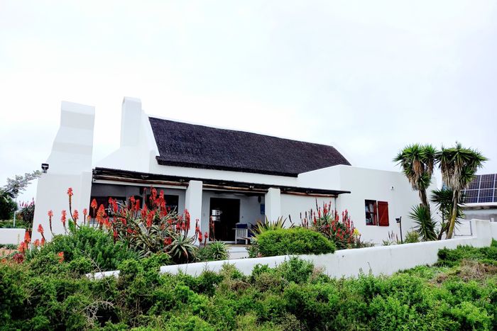 Jacobsbaai House For Sale: 4 beds, ocean views, solar power, and braai facilities.