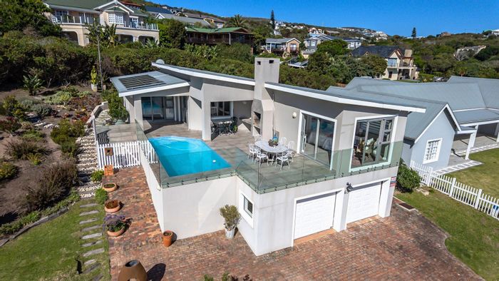 House For Sale in Brenton On Sea: Ocean views, pool, eco-friendly features, spacious garage.