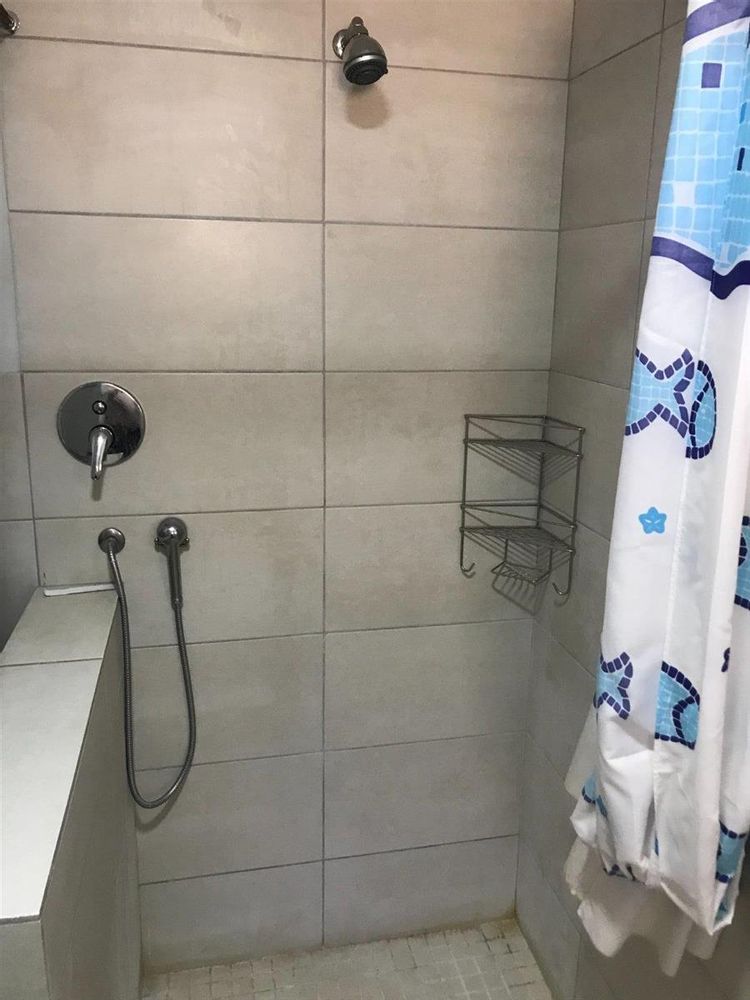 Flat open type shower to accomodate disabled persons
