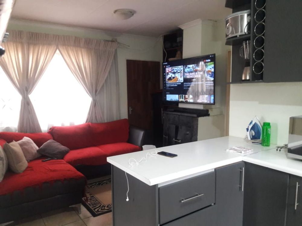 Open plan lounge has fireplace  with kitchen island