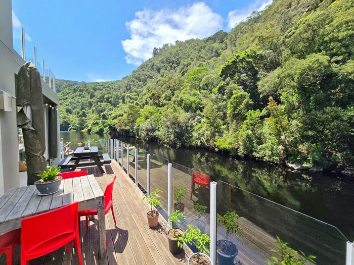 Riverfront house in Wilderness Central for sale, featuring open-plan living and private deck.