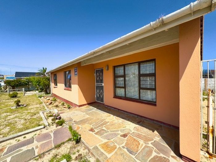 For Sale: House in Strandfontein Village with spacious yard, built-in braai, and parking.