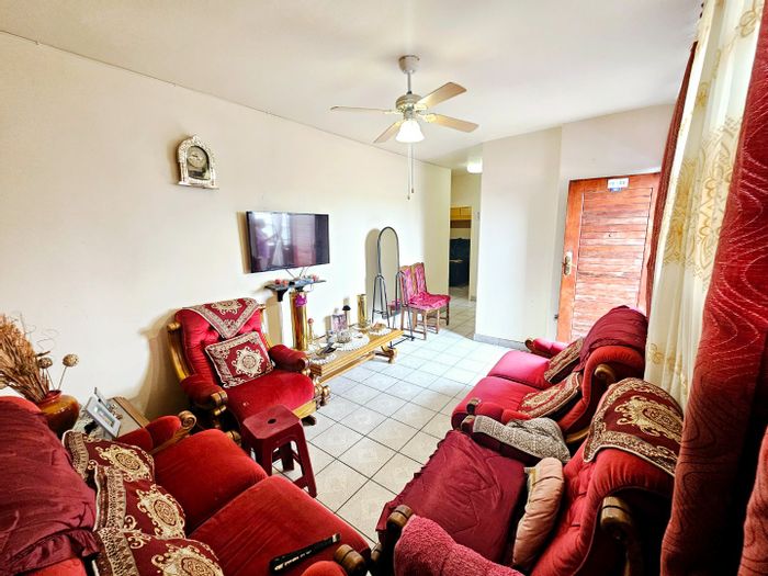 2 Bedroom Apartment for Sale in Laudium with built-in cupboards and lounge area.