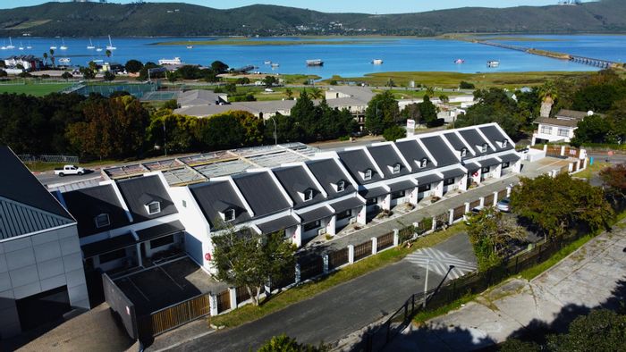 Knysna Central Apartment For Sale: Open-plan living, balcony views, communal braai area.