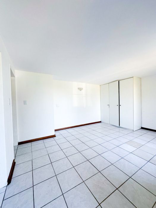 Ruimsig Apartment To Rent: Open-plan living, kitchenette, pool, secure parking included.