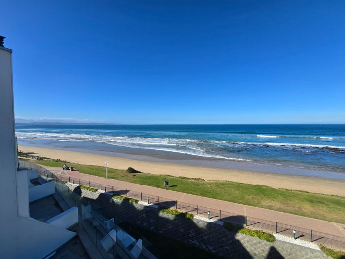 Beachfront apartment in Hartenbos Central with ocean views, pool, and parking. For Sale.