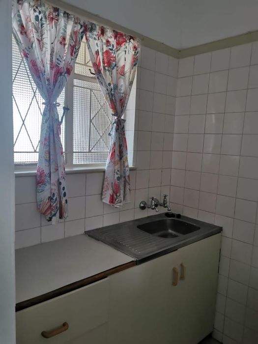 Quigney Apartment To Rent: Communal flat with kitchen, bathtub, and shared utilities.