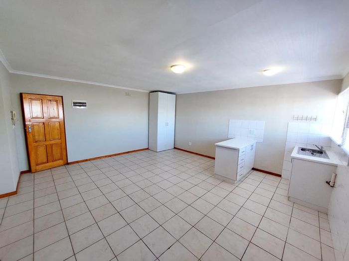 Plumstead Apartment To Rent: Spacious bachelor, open-plan kitchen, communal bathroom access.