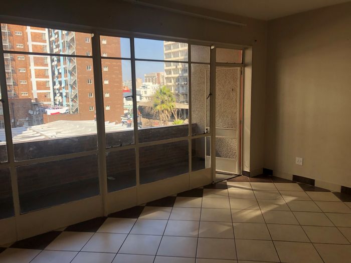 Flat to Rent in Hillbrow: Spacious unit, kitchenette, secure building, near amenities.