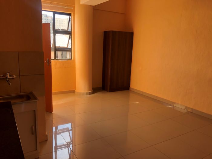 Flat To Rent in Johannesburg Central: Spacious unit, kitchenette, security, near transport and amenities.